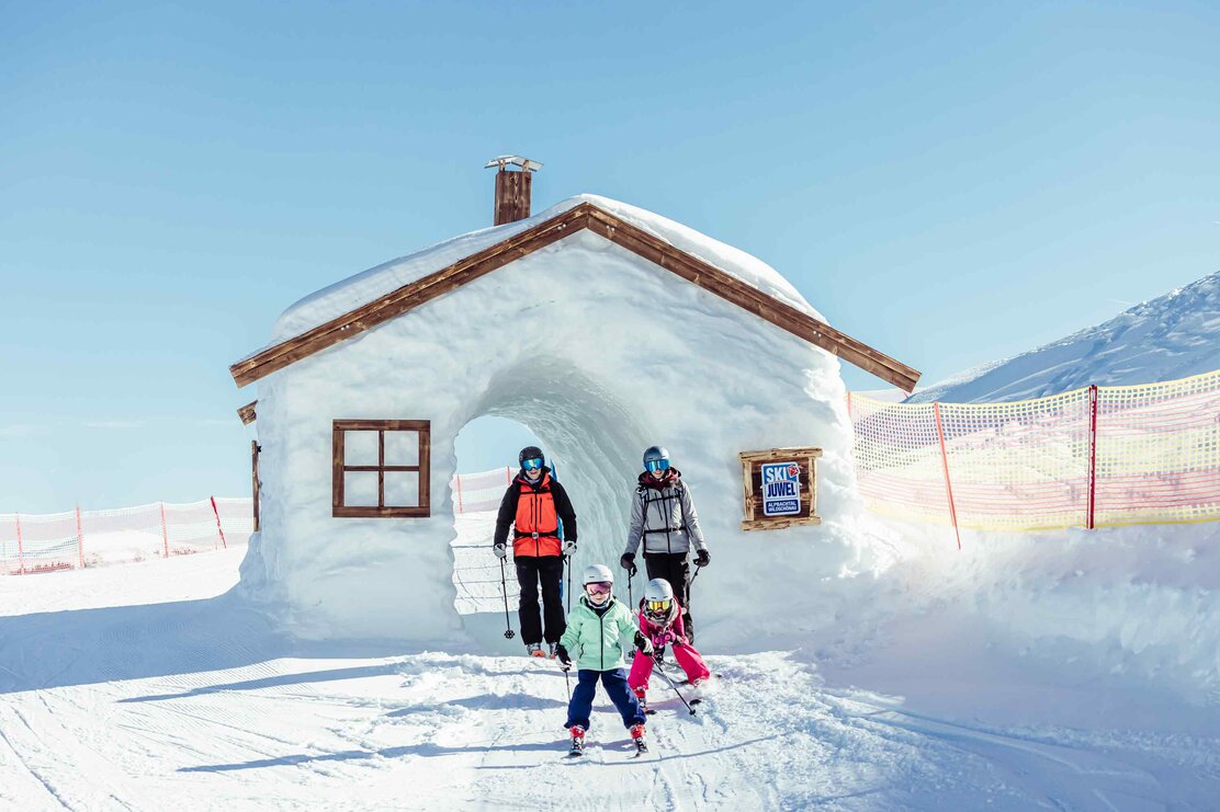 Eine Mutter und ein Vater, fahren gemeinsam mit ihren zwei Kindern durch die Funslope im Ski Juwel Alpbachtal Wildschönau  | © Alpbachtal Tourismus | shootandstyle 