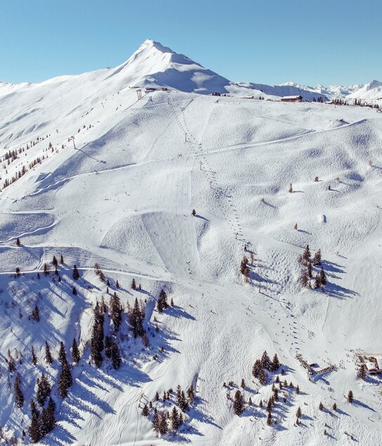 Eine Panoramaaufnahme vom Skigebiet Ski Juwel Alpbachtal Wildschönau, verschneite Winterlandschaft, Skilifte und das Wiedersberger Horn sind zu sehen  | © Alpbachtal Tourismus | S. Oberleitner