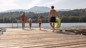 Eine vierköpfige Familie geht am Steg entlang in Richtung Einstieg zum Reintalersee  | © Alpbachtal Tourismus | shootandstyle 