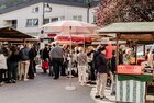 Bauernmarkt Brixlegg | © Brixlegger Wirtschaft | Genusskind Menschen flanieren über den Bauernmarkt in Brixlegg, links und rechts stehen Marktstände mit regionalen Anbietern, Sonnenschirme stehen vor den Ständen. | © Brixlegger Wirtschaft | Genusskind
