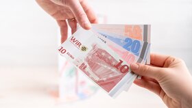 Nahaufnahme von zwei Händen, die gemeinsam WiR-Gutscheine halten. | © WiR Alpbachtal | Genusskind
