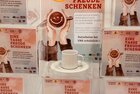 Boxen Eine Tasse Freude schenken | © WiR Alpbachtal Plexiglasboxen und Plakate vom Projekt "Eine Tasse Freude schenken" stehen auf einem Tisch, auf den Boxen eine weiße Tasse auf einem Untersetzer. | © WiR Alpbachtal